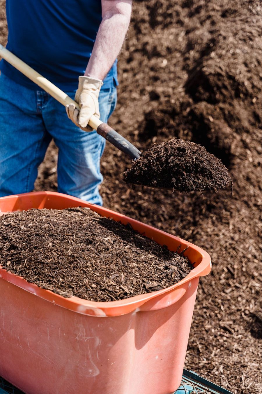 Fresh mulch being added to a landscape bed